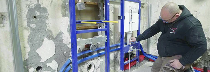 Person montiert Unterputzspülkasten